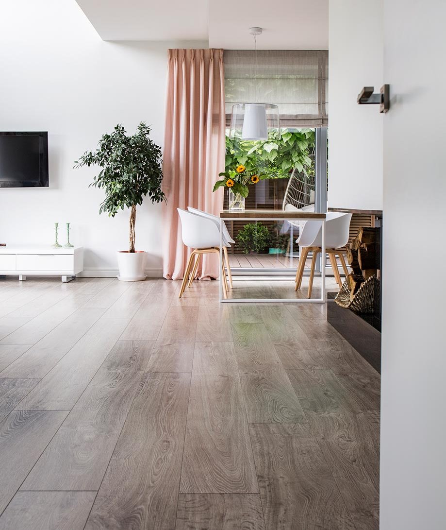 Gschwander Vinylböden und Designböden - Einfache Verlegung und optimale Hygieneeigenschaften Blick in ein helles Wohnzimmer mit Essbereich und einem grauen Designboden